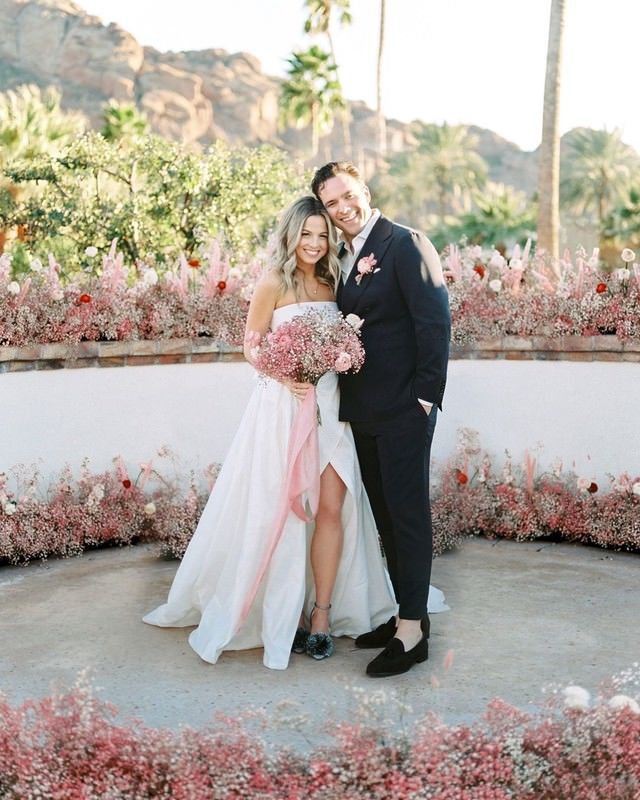 bride and groom surrounded by pink baby's breath