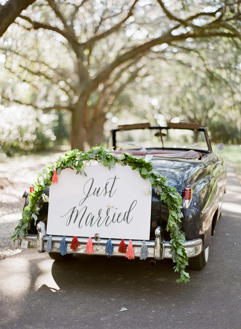 wedding getaway car with just married sign and tassel garland