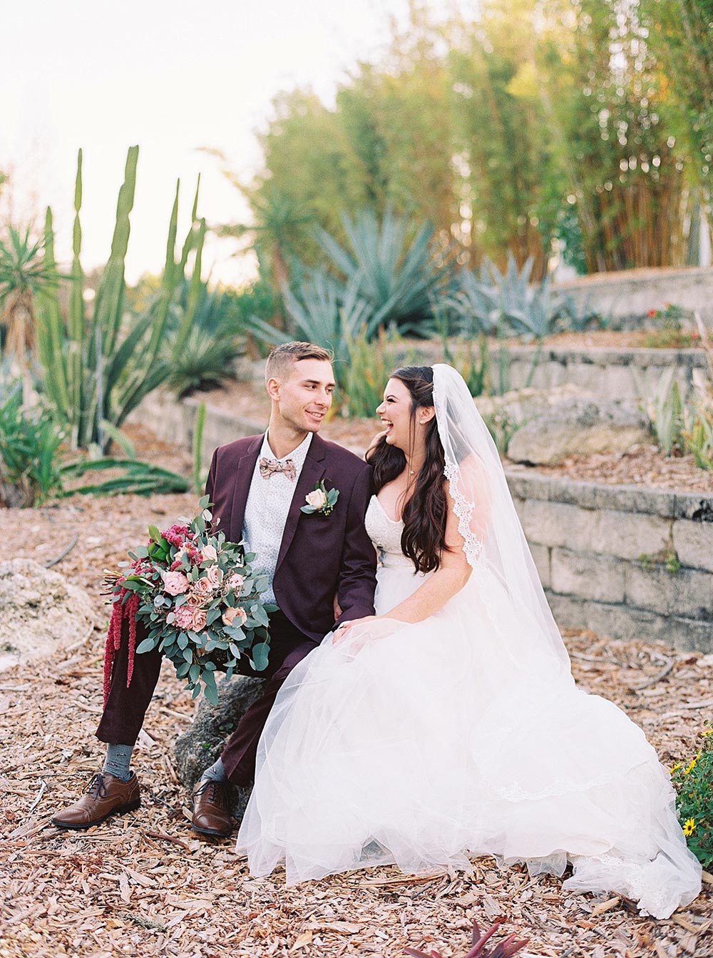 maroon groom suit and strapless wedding dress with veil