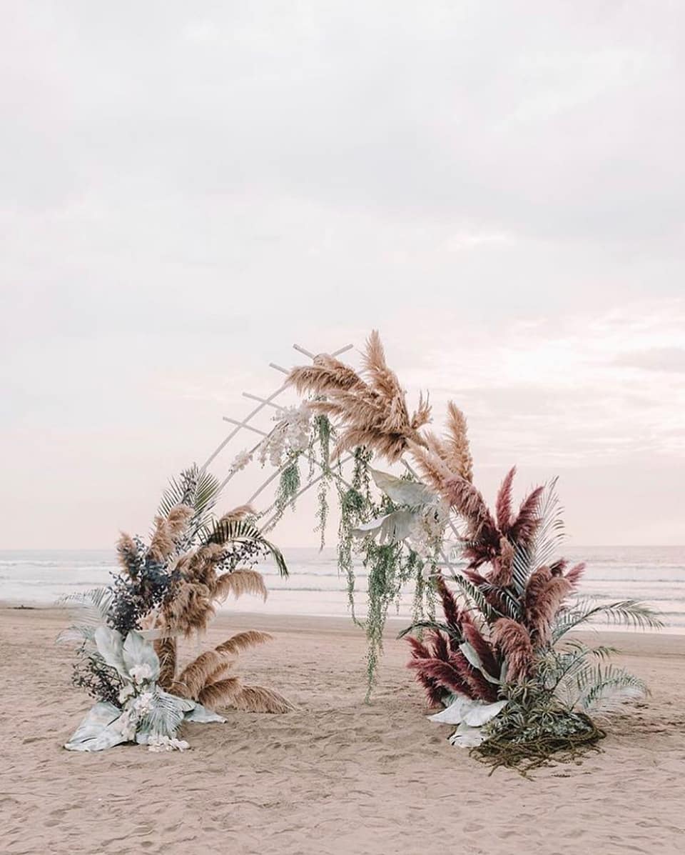 dyed flower wedding backdrop with pampas grass for a beach wedding
