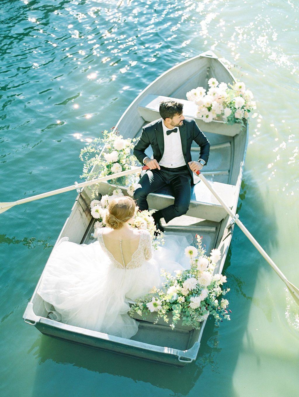 tulle and lace bridal gown with black groom tux row boat elopement