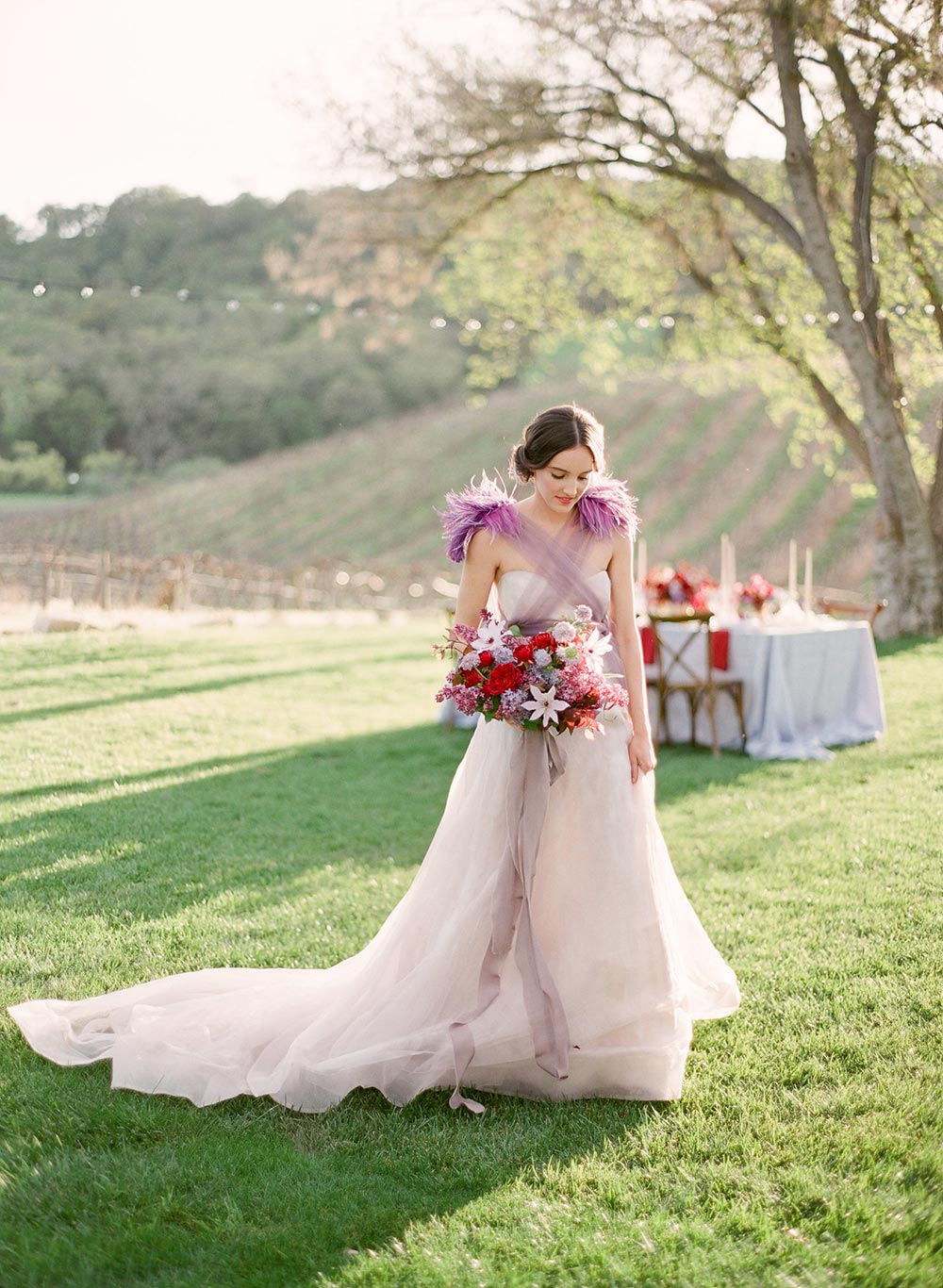 lavender wedding dress with feathers and tulle and a burgundy bridal bouquet
